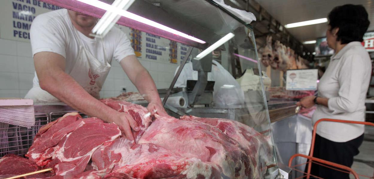 Funcionário carrega pedaços de carne em açougue no estado de São Paulo